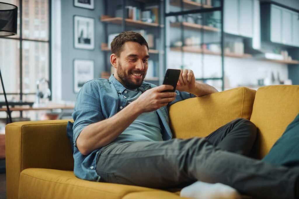 WLAN oder mobile Daten: Mann auf Sofa